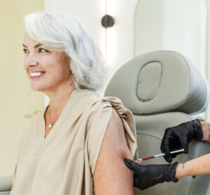 A smiling woman receives weight loss injections in Burlington