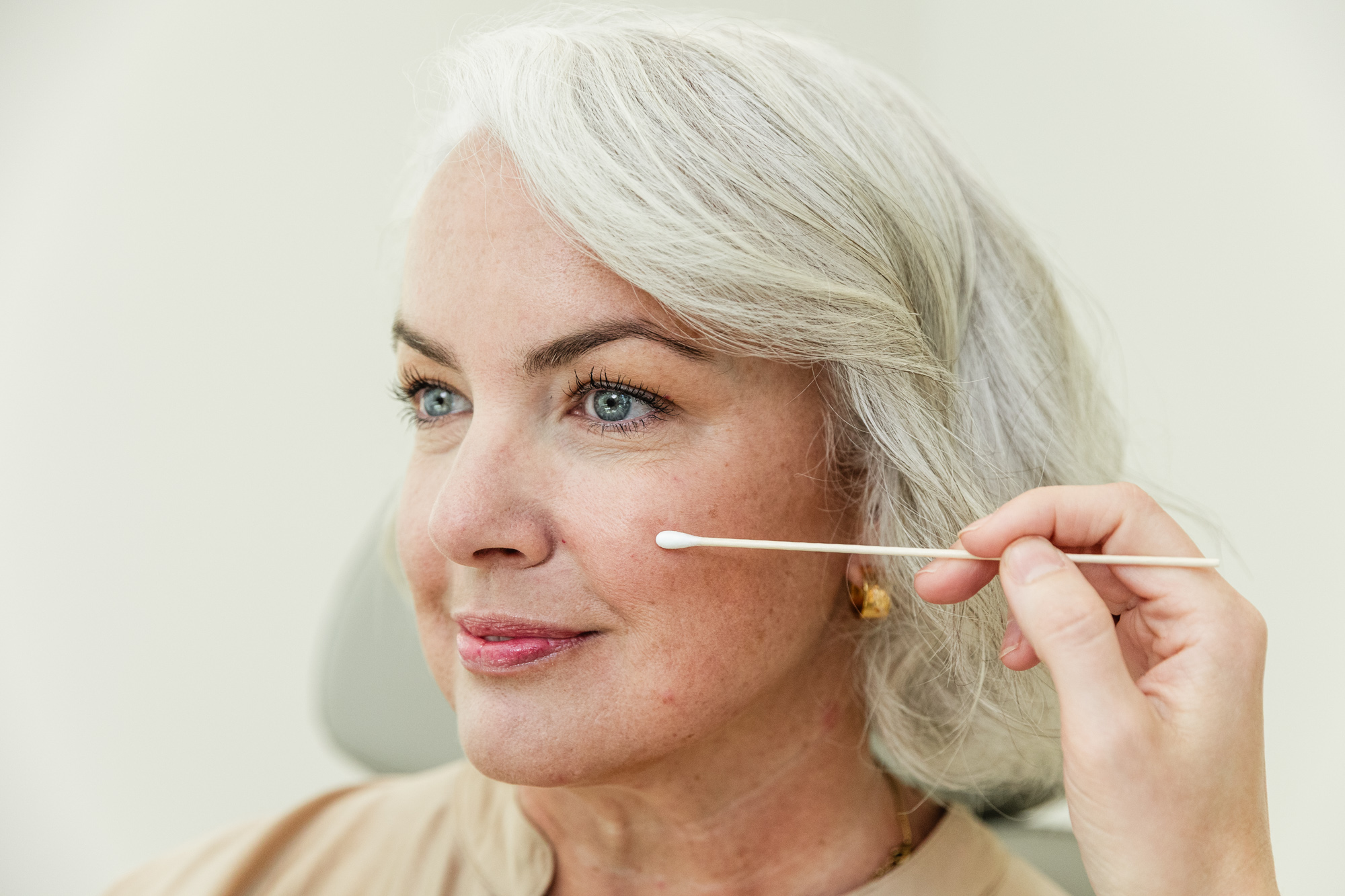 A woman smiles after receiving filler for wrinkles in Chapel Hill